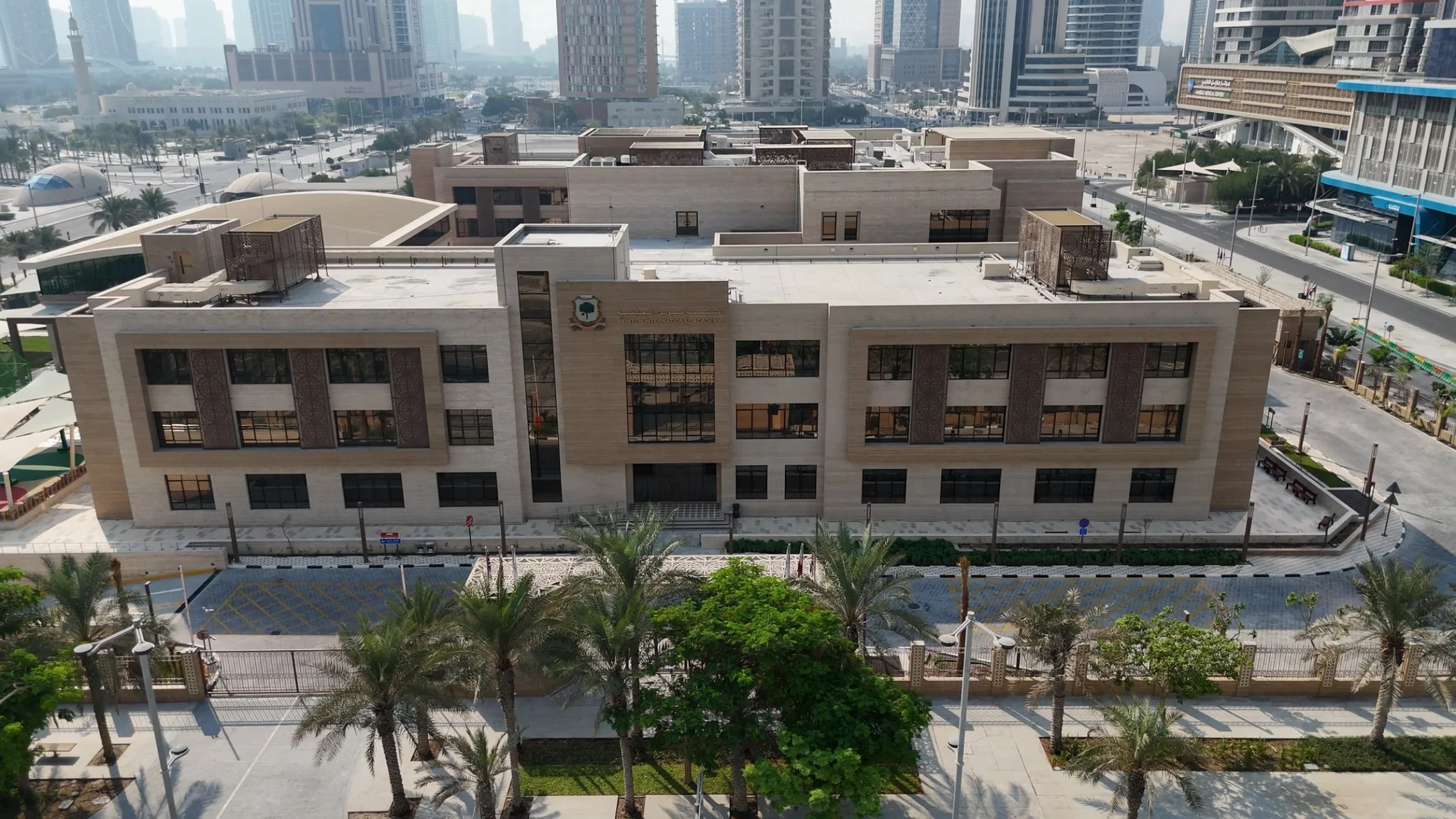 Modern architectural exterior of the Newton Schools campus in Doha, Qatar.