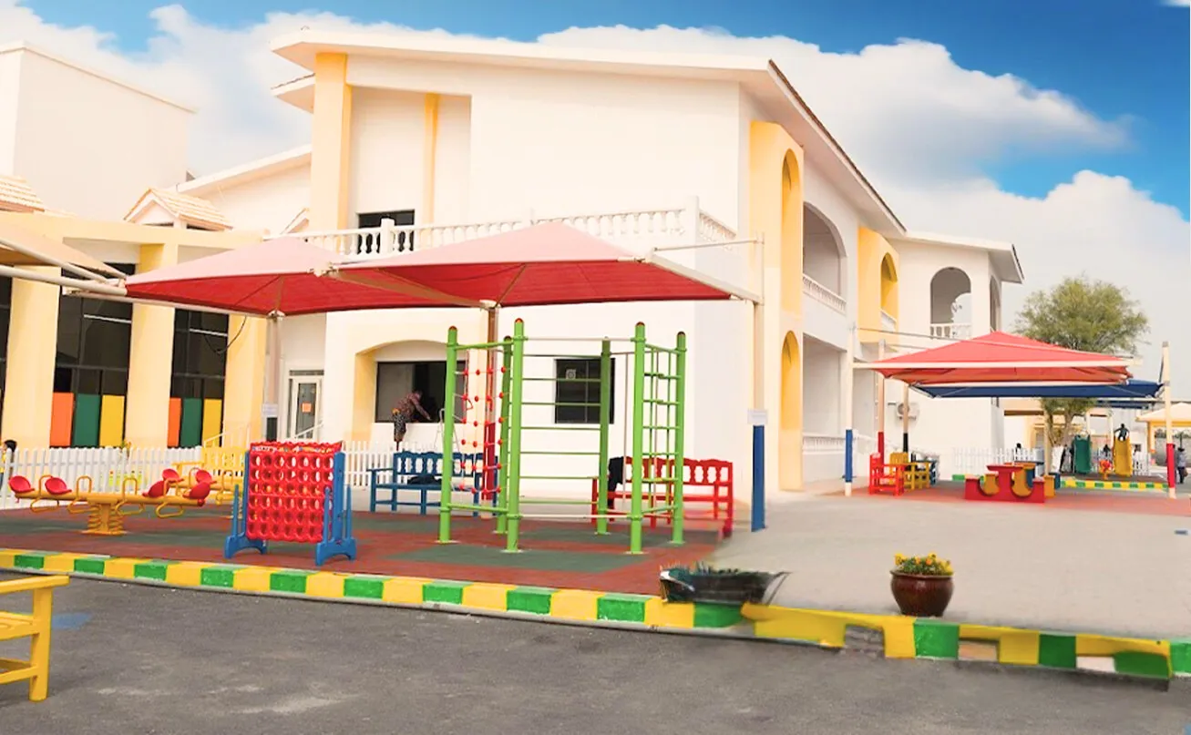 Outdoor play area and school building at the Newton International School (NIS) D-Ring Road campus in Doha, Qatar.